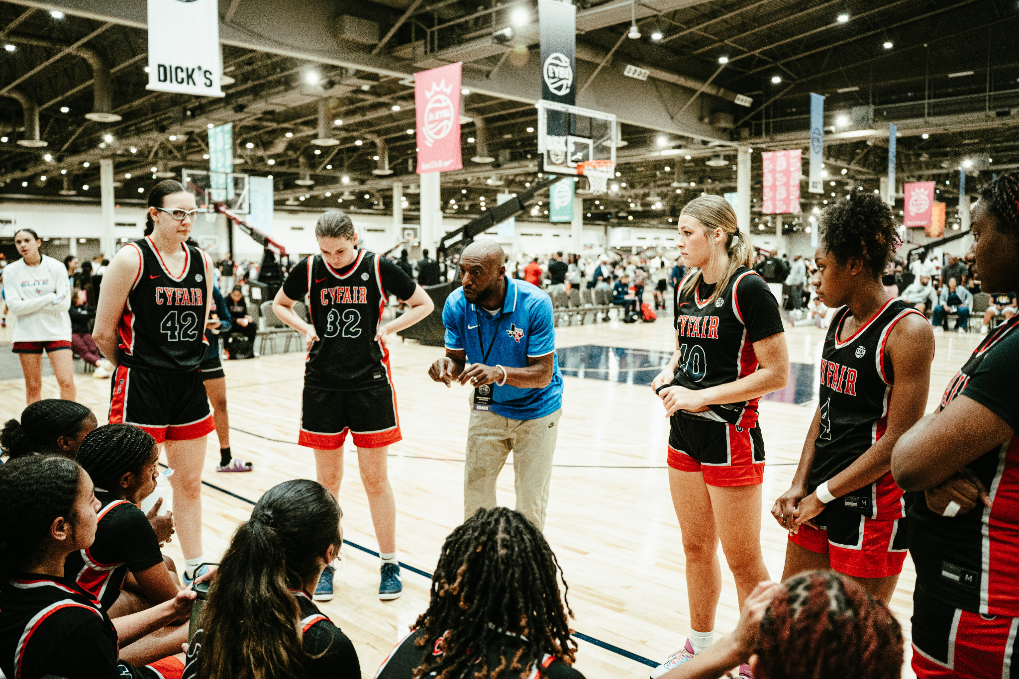 Girls basketball team gathered with a coach during competition